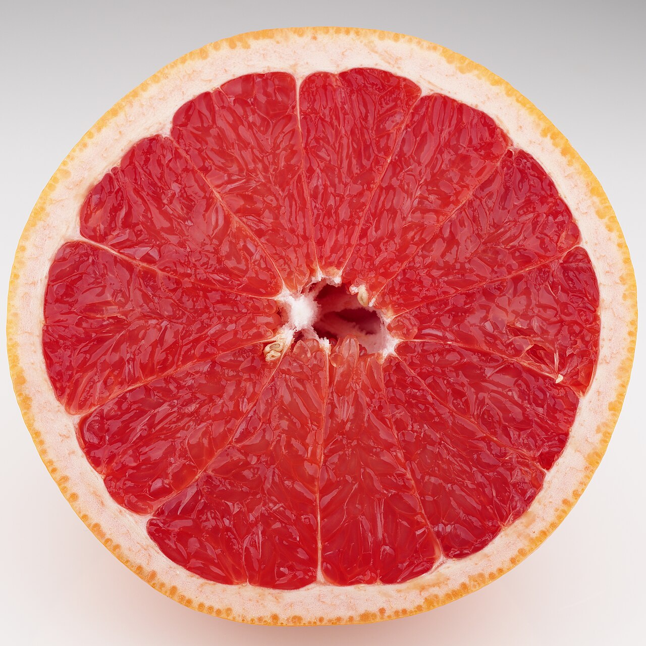 Spicchi ravvicinati della polpa rosata di un pompelmo